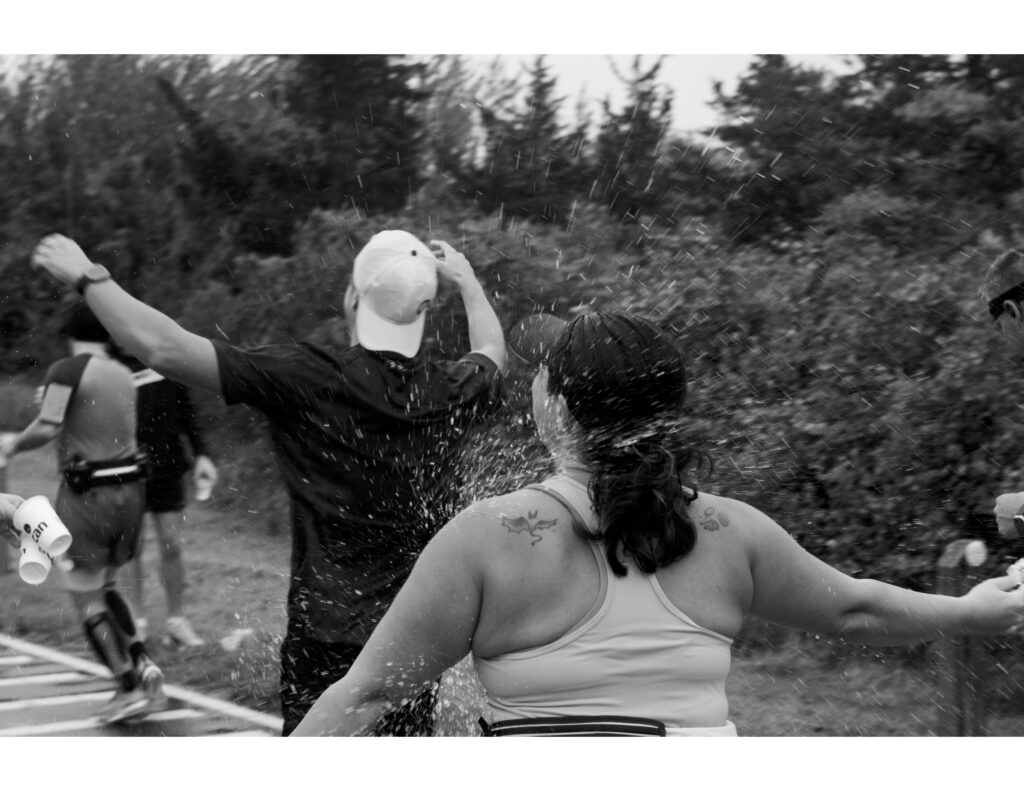 Black and white photograph of several people running and water splashing.